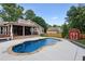 Scenic backyard showcasing pool, stone trim, patio and wood deck with an outdoor kitchen at 657 Polk Nw St, Marietta, GA 30064