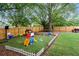 Large fenced in yard with mature trees, a play area, fire pit, shed and trampoline at 657 Polk Nw St, Marietta, GA 30064