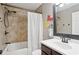 Bathroom with tiled bathtub and shower featuring a dark wood vanity and a framed mirror at 657 Polk Nw St, Marietta, GA 30064