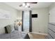 Cozy bedroom with neutral walls featuring a built in ceiling fan, a window, and gray furnishings at 657 Polk Nw St, Marietta, GA 30064