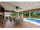 Inviting covered deck with wood floors, ceiling fans, television, and view of the backyard pool at 657 Polk Nw St, Marietta, GA 30064