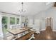 Bright dining area features large windows, hardwood floors, modern chandelier and rustic farmhouse furniture at 657 Polk Nw St, Marietta, GA 30064