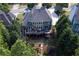 Aerial view of home with a large deck, manicured backyard, and lush trees at 702 Crescent Cir, Canton, GA 30115