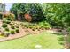 Landscaped backyard featuring a stone staircase leading to a fire pit and lush greenery at 702 Crescent Cir, Canton, GA 30115