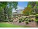Backyard with multiple tiers of mature trees, landscaping and a patio at 702 Crescent Cir, Canton, GA 30115