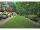 Sprawling backyard with lush grass and natural border of trees and shrubs at 702 Crescent Cir, Canton, GA 30115