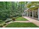 Expansive backyard with lush greenery and a patio under an elevated porch at 702 Crescent Cir, Canton, GA 30115