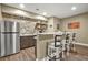 Finished basement bar area with stainless steel refrigerator and bar seating at 702 Crescent Cir, Canton, GA 30115
