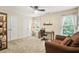 Bedroom with carpeted floors features a desk, chair, ceiling fan and a large window with natural light at 702 Crescent Cir, Canton, GA 30115