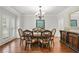 Formal dining room with hardwood floors, wainscoting, a chandelier, and elegant furniture at 702 Crescent Cir, Canton, GA 30115