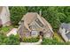 Aerial view of beautiful brick home with lush landscaping and mature trees at 702 Crescent Cir, Canton, GA 30115
