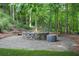 A cozy backyard fire pit with stone surround and wooded views at 702 Crescent Cir, Canton, GA 30115