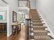 Staircase and hardwood flooring in an open foyer space with stylish console table and decor at 702 Crescent Cir, Canton, GA 30115