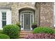 Charming front door with sidelights, decorative glass, and manicured landscaping at 702 Crescent Cir, Canton, GA 30115