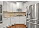 Modern kitchen with white cabinetry, stainless steel appliances, and a stylish tile backsplash at 702 Crescent Cir, Canton, GA 30115