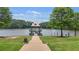 Paved walkway leading to pier and lake with trees and landscaping at 702 Crescent Cir, Canton, GA 30115