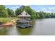 Two story pier extending into lake with surrounding trees and landscaping at 702 Crescent Cir, Canton, GA 30115