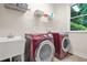 Laundry room with washer, dryer, utility sink and a window offering natural light at 702 Crescent Cir, Canton, GA 30115