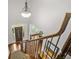 View of front door from the top of carpeted stairs with decorative iron and wood banister and a modern light fixture at 702 Crescent Cir, Canton, GA 30115