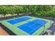 Features tennis courts with blue surface, green surrounding area, net, and fenced at 702 Crescent Cir, Canton, GA 30115