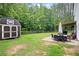 Expansive backyard featuring a storage shed, manicured lawn, and outdoor dining area with covered pergola at 1417 Woodrow Kay Rd, Rockmart, GA 30153