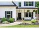 Close-up of the home's front porch, featuring a comfortable seating area, decorative plants, and stylish black door at 1417 Woodrow Kay Rd, Rockmart, GA 30153