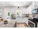 Bright and airy kitchen boasts white cabinetry, granite countertops, stainless appliances, and backyard view at 1417 Woodrow Kay Rd, Rockmart, GA 30153