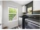 Modern laundry room featuring a window with green view, overhead cabinets, and shelving at 1417 Woodrow Kay Rd, Rockmart, GA 30153