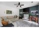 Spacious living room featuring a stone fireplace, green accent wall, a ceiling fan, and comfortable seating at 1417 Woodrow Kay Rd, Rockmart, GA 30153
