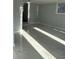 A bright basement with gray walls and large tile flooring leading to another area at 6774 Collier Rd, Riverdale, GA 30296