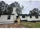 Back view of home with wood stairs leading to the back entrance with new paint at 6774 Collier Rd, Riverdale, GA 30296