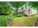 Lush backyard featuring a well-maintained lawn, mature trees, and a wooden deck for outdoor enjoyment at 3040 Majestic Park Ct, Duluth, GA 30096
