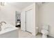 Bright bathroom featuring white vanity, toilet, and open door to the main bedroom at 3040 Majestic Park Ct, Duluth, GA 30096