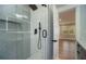 Modern bathroom with a glass-enclosed shower featuring sleek fixtures, alongside a doorway to the adjacent bedroom at 3470 Glenwood Rd, Decatur, GA 30032