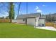 Rear exterior view showing the home's siding, new backyard lawn, and wooden deck at 3470 Glenwood Rd, Decatur, GA 30032