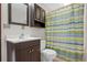 Bathroom features a toilet, shower with decorative curtain, sink and vanity, and upper storage cabinet at 3966 N Indian Nw Cir, Kennesaw, GA 30144