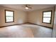 Carpeted bedroom featuring two windows and ceiling fan for natural lighting and air circulation at 3966 N Indian Nw Cir, Kennesaw, GA 30144
