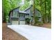 Charming gray two-story home with a two-car garage and a long driveway surrounded by lush trees at 3966 N Indian Nw Cir, Kennesaw, GA 30144