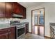 Galley kitchen features stainless steel range, granite countertops, and dark wood cabinets with tiled backsplash at 3966 N Indian Nw Cir, Kennesaw, GA 30144