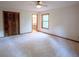 Main bedroom featuring neutral carpet, large closet, and window overlooking the backyard at 3966 N Indian Nw Cir, Kennesaw, GA 30144
