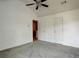 Spacious bedroom featuring neutral walls, carpet, a ceiling fan, and multiple doors at 6684 Crane Ave, Fairburn, GA 30213