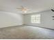 Spacious bedroom featuring neutral walls, carpet, a ceiling fan, and a window at 6684 Crane Ave, Fairburn, GA 30213