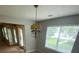Cozy dining room featuring a charming chandelier, large window, and view of the sunroom at 6684 Crane Ave, Fairburn, GA 30213