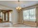 Bright dining room features modern chandelier, natural light, and smooth wood laminate floors at 6684 Crane Ave, Fairburn, GA 30213