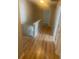Upstairs hallway featuring laminate flooring and neutral paint at 6684 Crane Ave, Fairburn, GA 30213