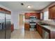 Well-lit kitchen with stainless steel appliances, wood cabinets, and plenty of counter space at 6684 Crane Ave, Fairburn, GA 30213