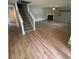 Spacious living room with light wood floors, a fireplace, and a view of the staircase at 6684 Crane Ave, Fairburn, GA 30213