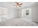 Bedroom with a tray ceiling, ceiling fan, carpet floors, and a window at 5057 Lower Elm St, Atlanta, GA 30349