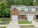 Inviting two-story townhome boasts brick accents, attached garage, and lush greenery at 5057 Lower Elm St, Atlanta, GA 30349