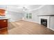 Spacious living room with a cozy fireplace, ceiling fan, and a door to the back at 5057 Lower Elm St, Atlanta, GA 30349